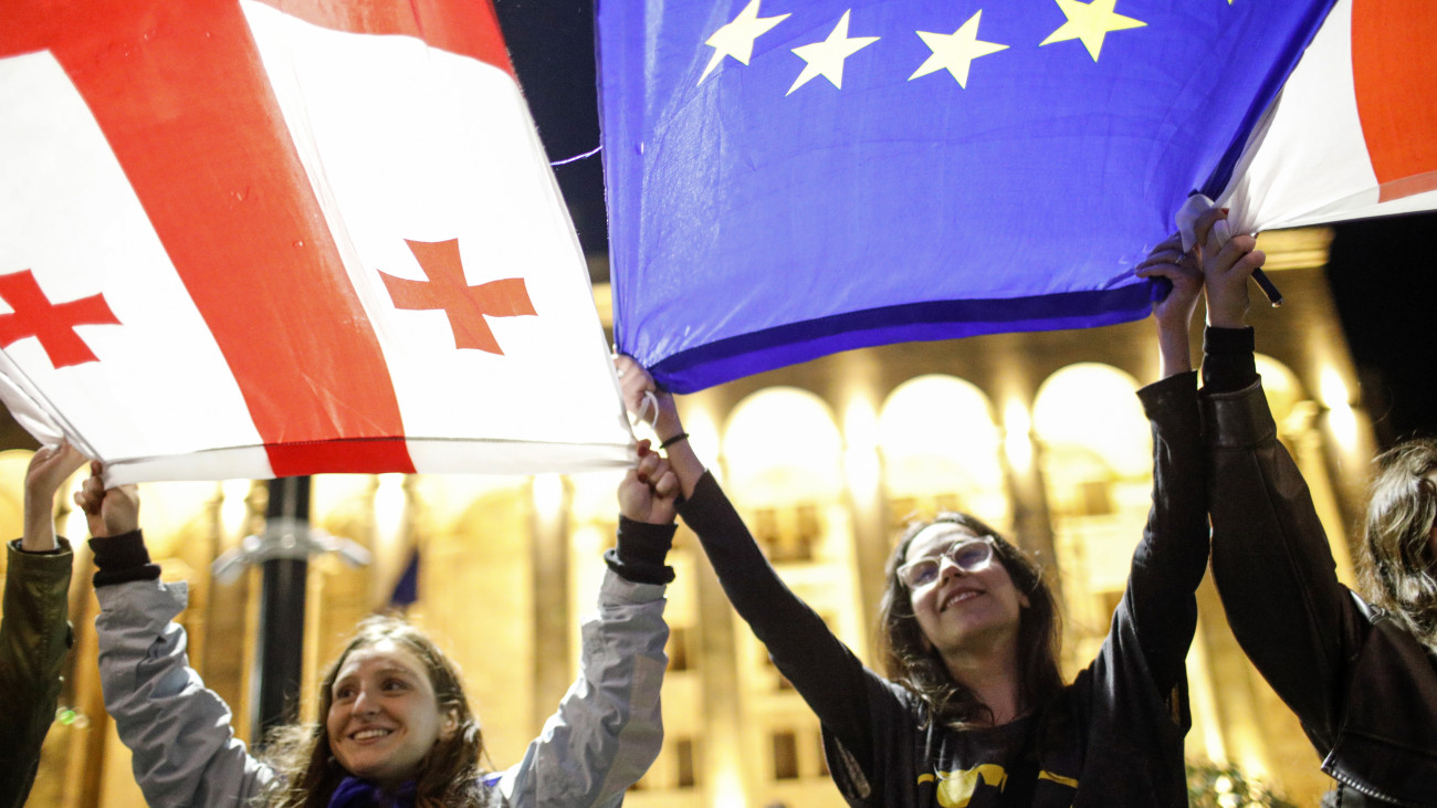 A külföldiügynök-törvény ellen tüntetők nemzeti és európai uniós zászlóval Tbilisziben 2024. május 13-án. A törvénytervezet alapján előírnák, hogy azok a szervezetek, amelyek anyagi eszközeinek több mint 20 százalékát külföldről finanszírozzák, külföldi ügynökökként regisztráltassák magukat.