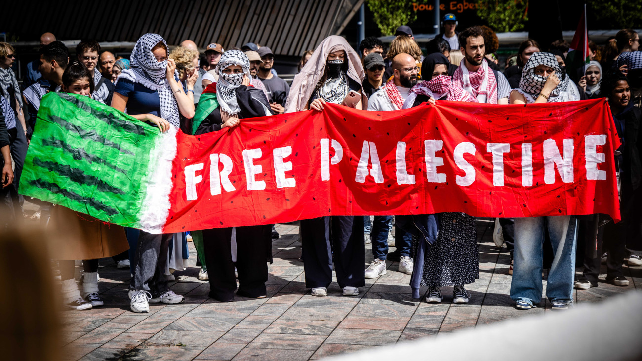 Palesztinpárti egyetemista diákok tüntetnek a rotterdami központi pályaudvaron 2024. május 16-án. A hallgatók azt próbálják elérni demonstrációikkal, hogy iskolájuk szakítsa meg az izraeli oktatási intézményekkel való kapcsolatait. A megmozdulást eredetileg az Erasmus Egyetemen tartották volna, de az intézményt a tüntetés idejére lezárták. A Hamász palesztin iszlamista szervezet fegyveresei 2023. október 7-én támadást indítottak Izrael ellen, az izraeli haderő pedig válaszul légi és szárazföldi hadműveleteket hajt végre a Gázai övezetben. A palesztin egészségügyi minisztérium szerint az izraeli katonai műveletek eddig több mint 34 ezer palesztin életét követelték.