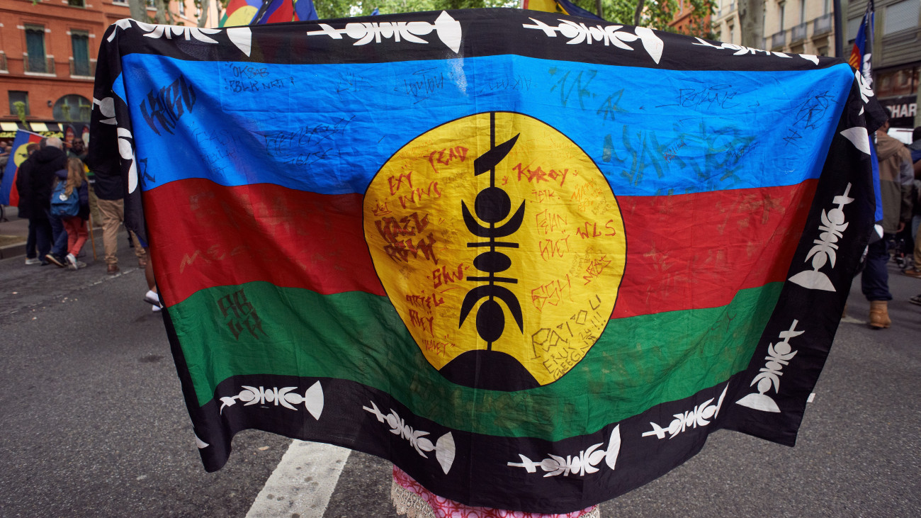 The Kanak&#039;s flag. New Caledonians (Kanaks) of Toulouse are taking to the streets in protest against the constitutional revision of the French Constitution by French President Macron to expand the electorate who can vote in local elections. Kanaks are saying they are already outnumbered by French people coming from the metropole, and the widening launched by Macron will be catastrophic for them. They are explaining this is plain colonialism. Since the vote on the law to widen the electorate, riots are happening in New Caledonia, and the French government is sending riot police and military to quell the insurrection there. Five people have already died. In Toulouse, France, on May 18, 2024. (Photo by Alain Pitton/NurPhoto via Getty Images)