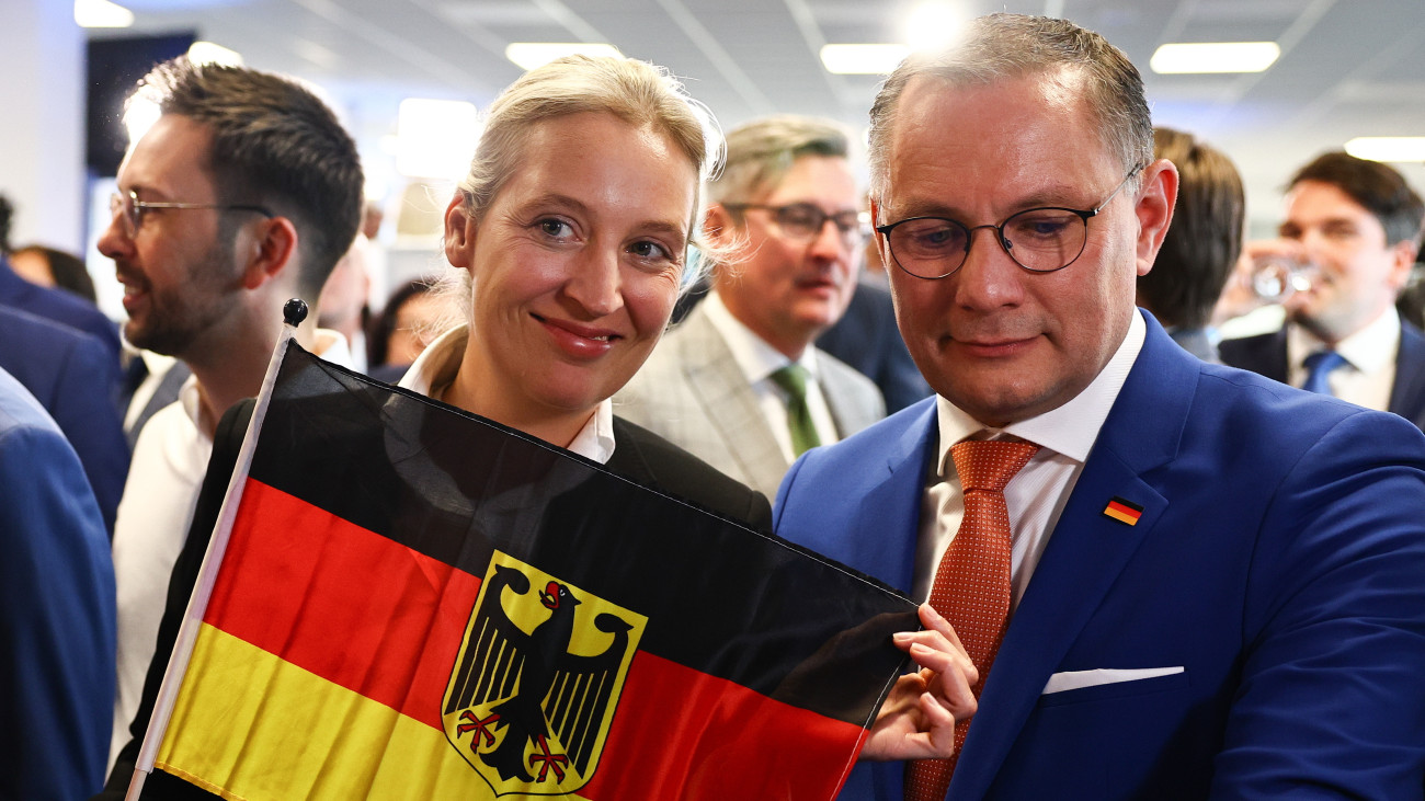 Tino Chrupalla, az ellenzéki Alternatíva Németországnak (AfD) párt társelnöke (j) és Alice Weidel, az AfD elnökhelyettese egy német zászlóval a párt berlini kampányközpontjában az európai parlamenti választások estéjén, 2024. június 9-én.