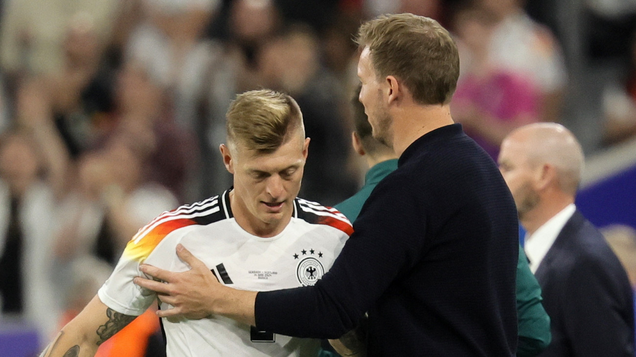 Julian Nagelsmann német szövetségi kapitány (j) megköszöni lecserélt játékosának, Toni Kroosnak a játékát a németországi labdarúgó Európa-bajnokság Németország és Skócia között az A csoportban játszott nyitómérkőzésén a müncheni Allianz Arénában 2024. június 14-én.
