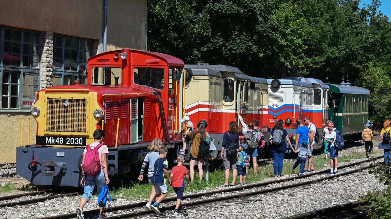 Résztvevők a járműkiállításon a gyermekvasút Széchenyihegy végállomásán, balról egy Mk48-as mozdony 2023. július 31-én. A Széchenyi-hegyi Gyermekvasúton 75 évvel ezelőtt, 1948. július 31-én indult el az első vonat utasokkal, az évfordulóra emlékezve izgalmas programokkal várták a családokat, egykori úttörő- és gyermekvasutasokat a Széchenyihegyen, az első szakasz végállomásán.