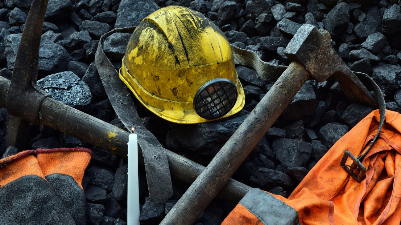 Vigil light, candle with the miner belongings (helmet, gloves, pickaxe, vest, belt) after the fatal accident in the mine