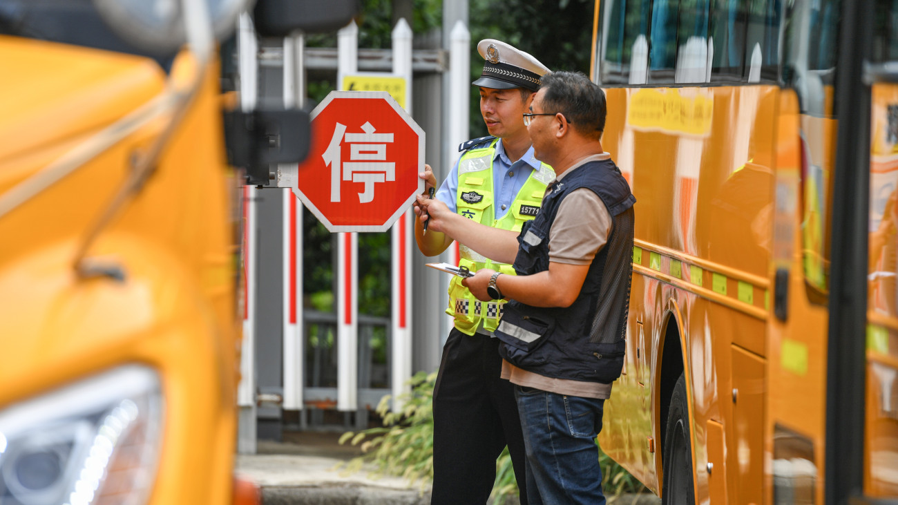 JINHUA, CHINA - AUGUST 22: A policeman checks school buses on August 22, 2024 in Jinhua, Zhejiang Province of China. Safety checks for school buses were started in many places of China as the new semester approaches. (Photo by Jin Sicheng/VCG via Getty Images)