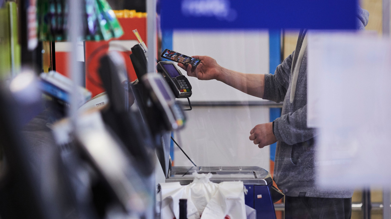 A custumer makes a smartphone electronic payment at a self-service check-out counter in a Tesco Plc supermarket in Wroclaw, Poland, on Tuesday, July 14, 2020. Tesco agreed to sell its business in Poland to Danish retailerÂ Salling Group A/S, as the U.K.s largest supermarket operator focuses on its domestic market in a consumer landscape upturned by the coronavirus.