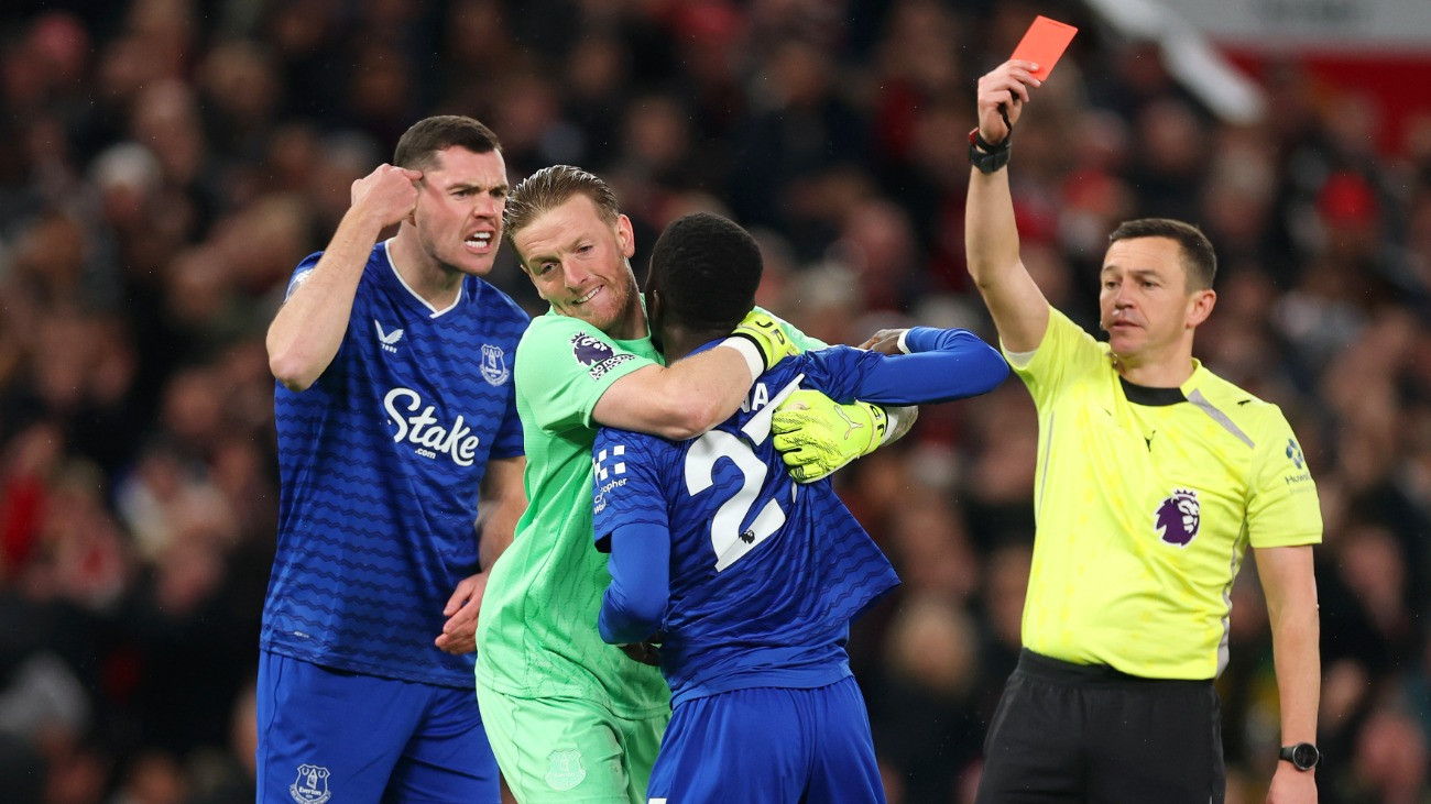 MANCHESTER, ENGLAND - NOVEMBER 24: Idrissa Gana Gueye of Everton is shown a red card by Referee Tony Harrington after clashing with teammate Michael Keane as he is restrained by Jordan Pickford during the Premier League match between Manchester United and Everton at Old Trafford on November 24, 2025 in Manchester, England.