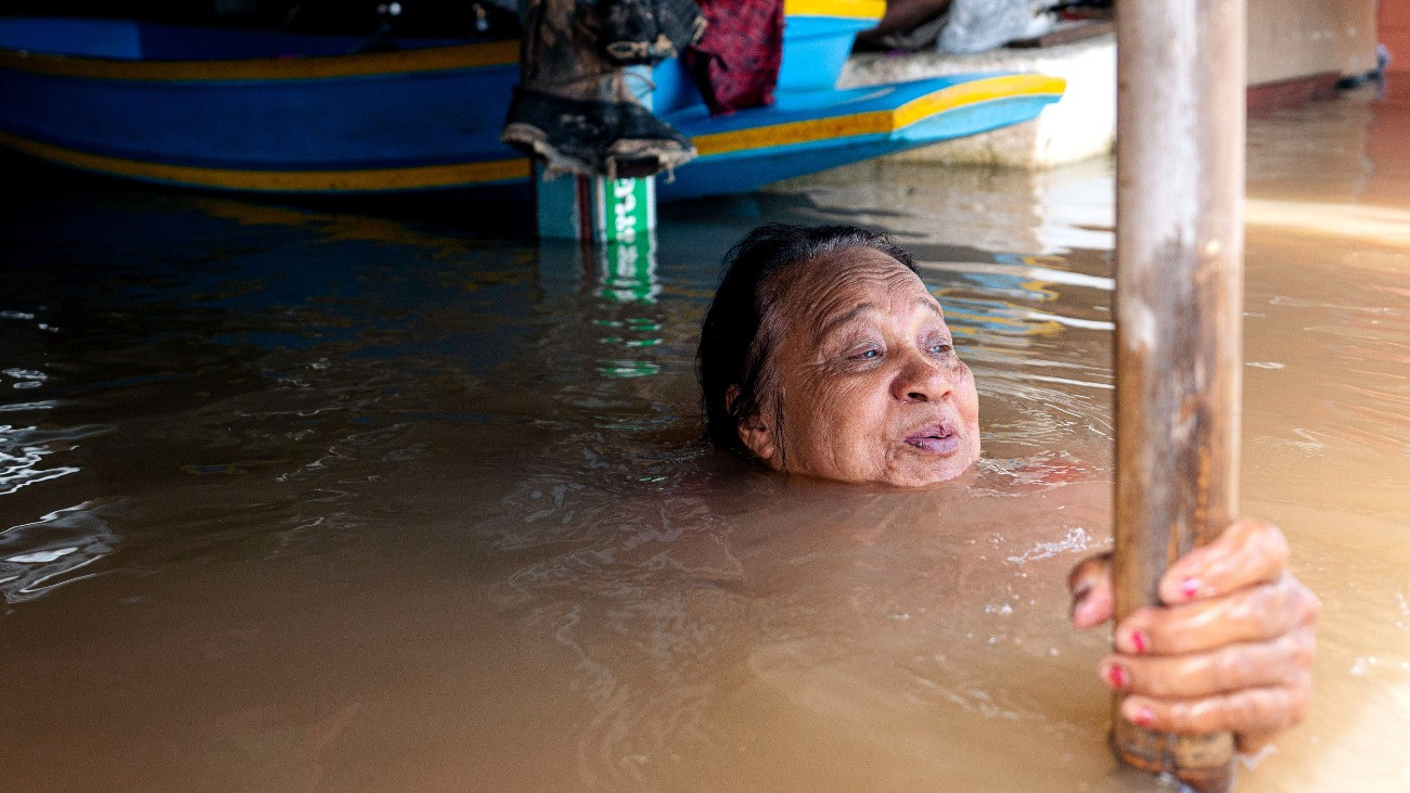 AYUTTHAYA, THAILAND - 2025/11/11: Residents in the Ban Dai Chang Temple Community in Sena District, Phra Nakhon Si Ayutthaya Province, are seen wading and floating in neck-high floodwaters. The area has been severely and continuously inundated for over four months, with water levels consistently exceeding one meter. The crisis is prolonged by the continuous, high discharge from the Chao Phraya Dam, causing the Chao Phraya River and its tributaries to overflow and forcing locals into extreme hardship, often relying on boats for survival. (Photo by Arnun Chonmahatrakool/Thai News Pix/LightRocket via Getty Images)