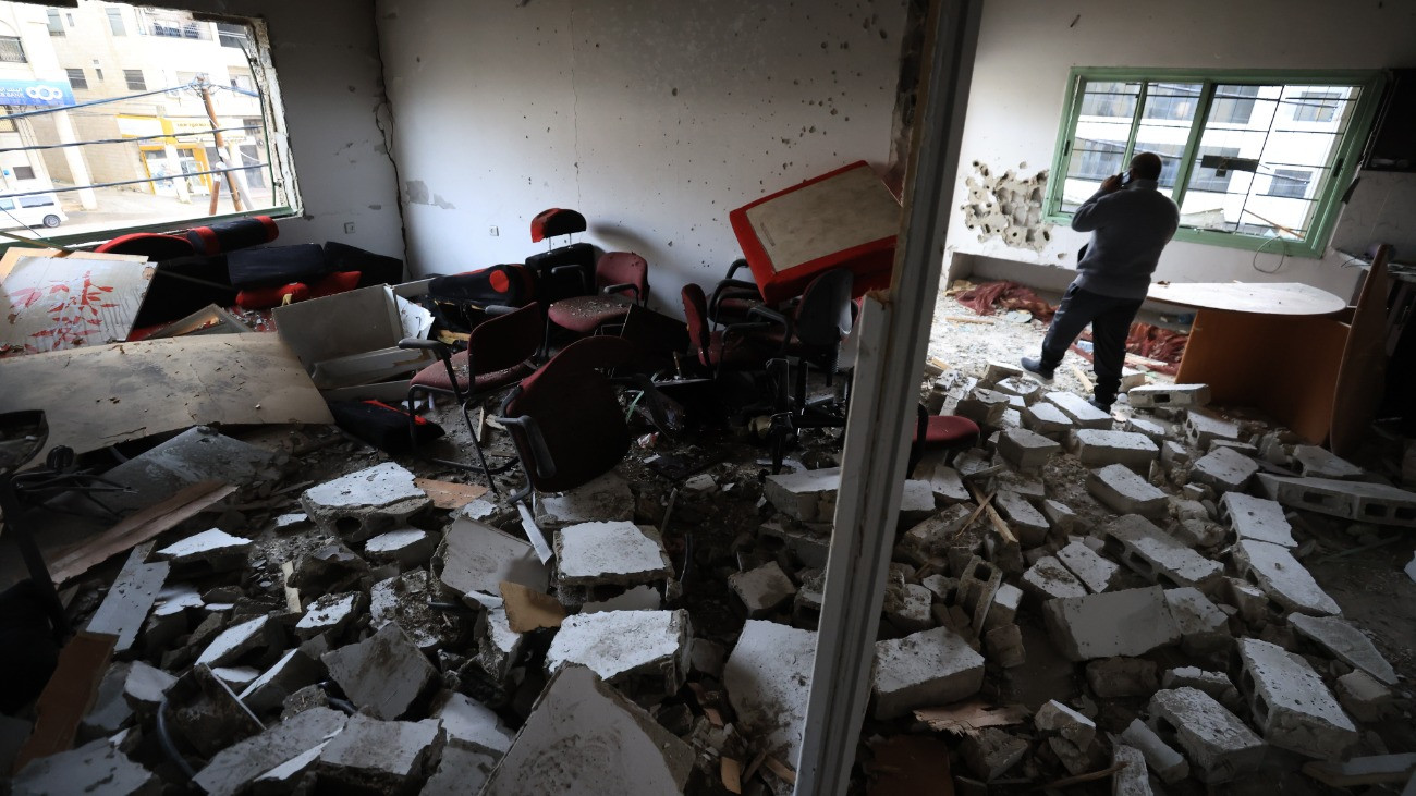 Palesztin férfi az izraeli rajtaütésben meggyilkolt Abd al-Rauf Astija palesztin fegyveres ciszjordániai Náblusz városában lévõ otthonának romjai között 2025. november 25-én. Astiját azért ölték meg, mert kapcsolatba hozták egy 2024 májusában, az Itamar zsidó telep közelében lévõ ellenõrzõpontnál elkövetett gázolásos támadással, amelyben két izraeli katona életét vesztette.