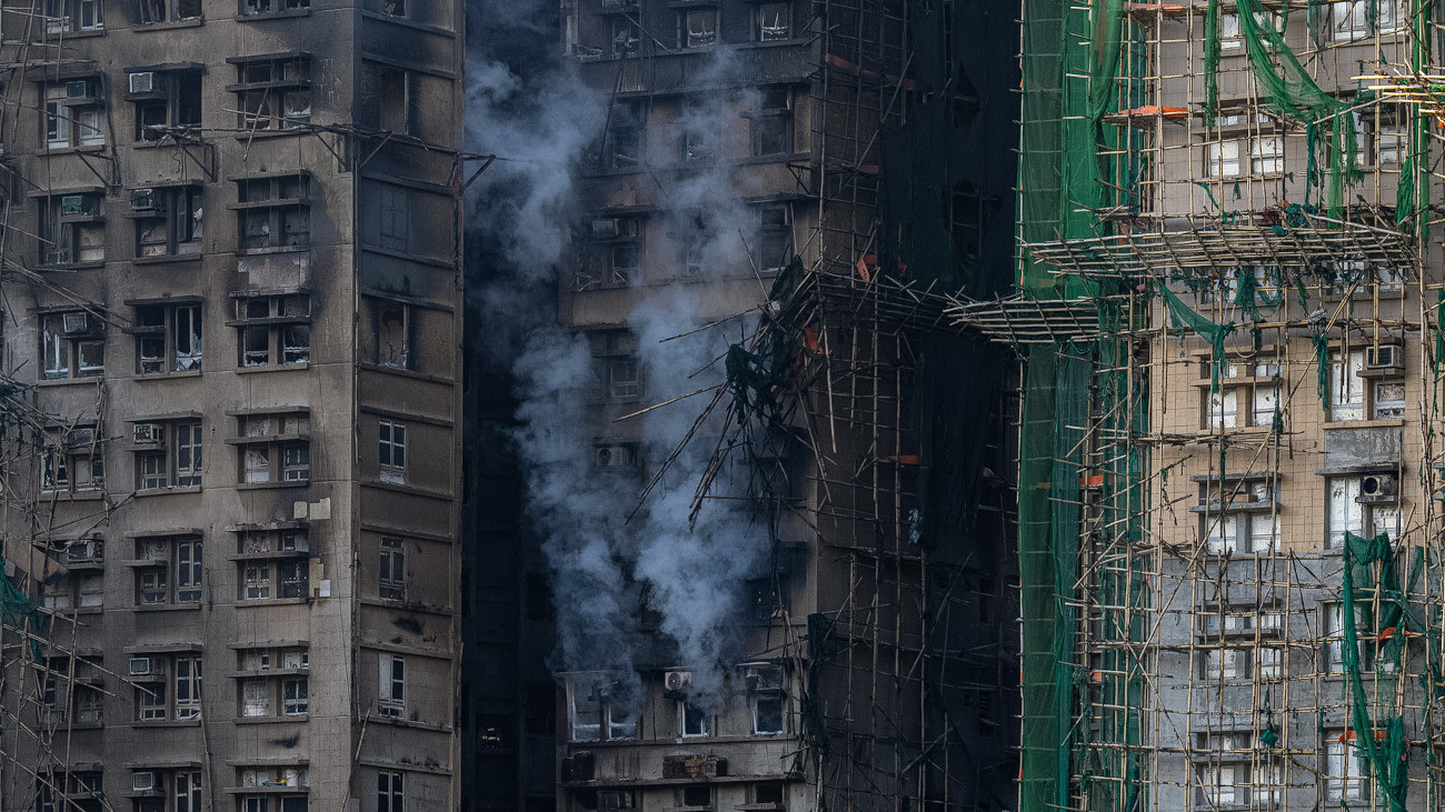 Kiégett toronyházak Hongkong Tai Po kerületében 2025. november 28-án, miután két nappal korábban lángra kapott a lakótömb egyik felújítás alatt lévõ részének bambuszállványzata és a lángok átterjedtek hét másik lakóépületre. A tûzvész halálos áldozatainak száma 94-re emelkedett, 300 embert még keresnek.