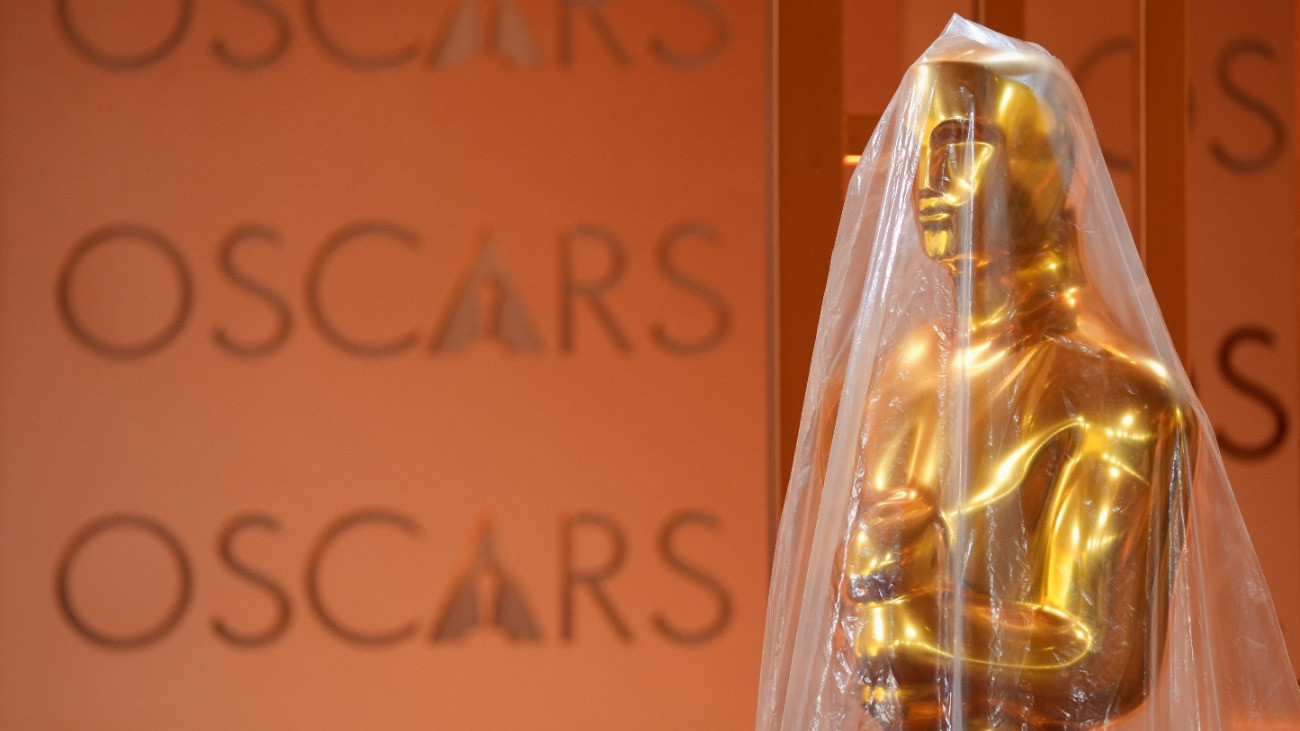 Mûanyag borítás védi a gála díszleteként használt Oscar-szobrok egyikét a Los Angeles-i Dolby Színház bejáratánál 2026. március 13-án, két nappal az Oscar-díjak 98. átadási ünnepsége elõtt.